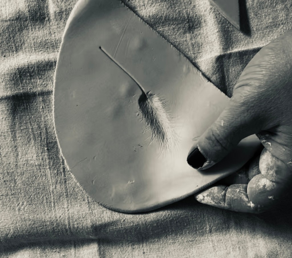Hände beim Töpfern von Keramik im Atelier. Feuchter Ton wird von Hand geformt, ohne Maschinen oder Formen. Authentischer Einblick in den Entstehungsprozess handgemachter Keramik, konzentrierte Arbeitsschritte im Töpferalltag einer kleinen Manufaktur.